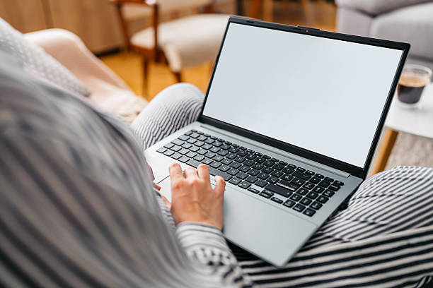 istock Young Woman Working On A Laptop While Sitting On The Sofa At Home 2220074073
