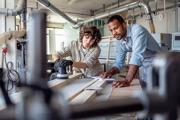 istock Diverse Male and Female Carpenters Collaborating in a Workshop with Woodworking Tools 2220074089