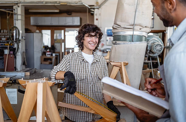 istock Diverse Carpenters Discussing Woodworking Project In Well-Lit Workshop With Custom Furniture Tools 2220074399
