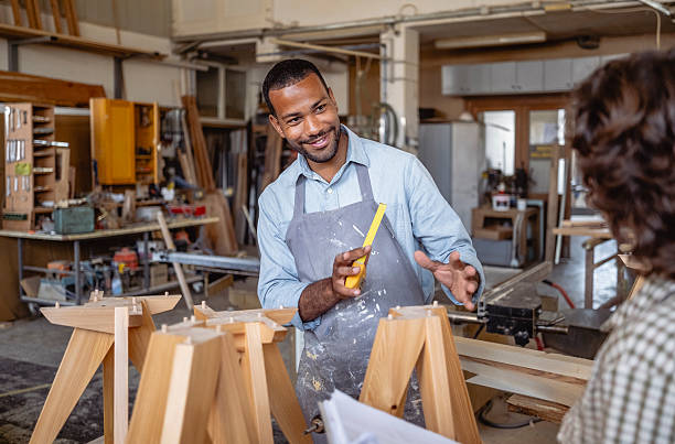 istock Diverse Male and Female Carpenters Collaborating in a Busy Workshop 2220074423