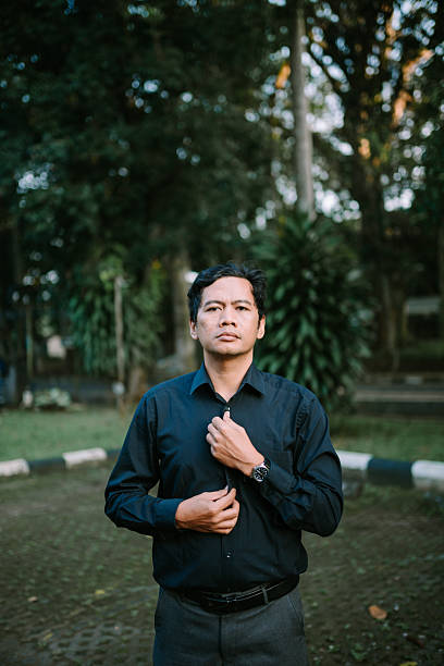 istock Thoughtful asian man prepares for the day outdoors in nature setting 2220075335