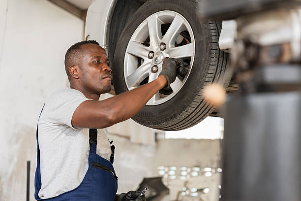 istock Auto Mechanic Working on Car Wheel in Garage, Professional Technician Changing Tire in Workshop, Car Service Specialist Repairing Vehicle Undercarriage 2220076008