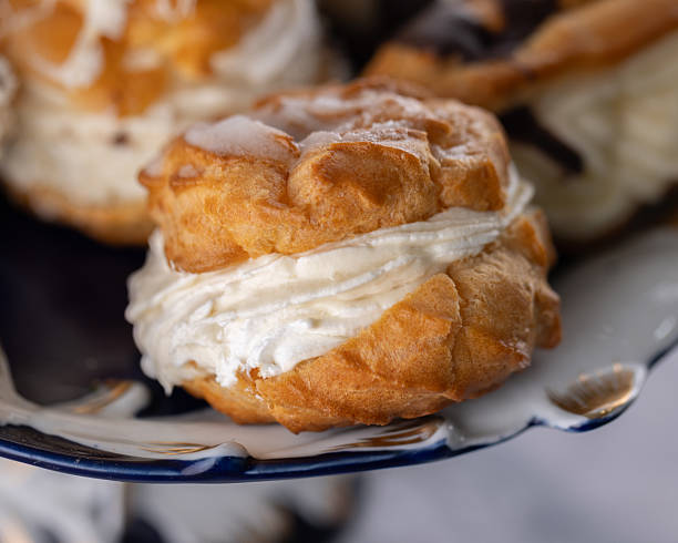 istock Cream-filled choux pastries with chocolate and white glaze 2220076179
