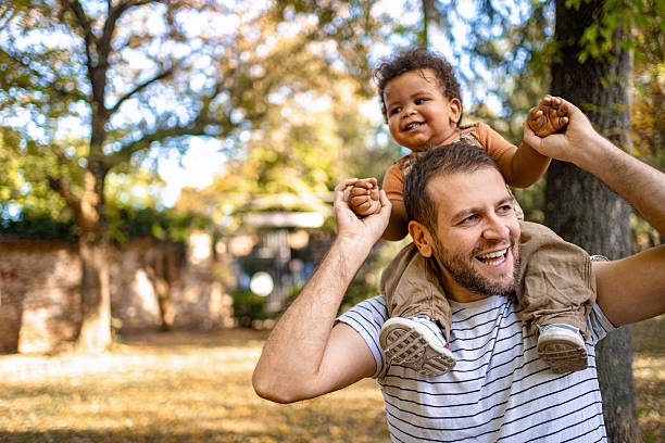 istock Father carrying his son on his shoulders in a park during autumn 2220079095