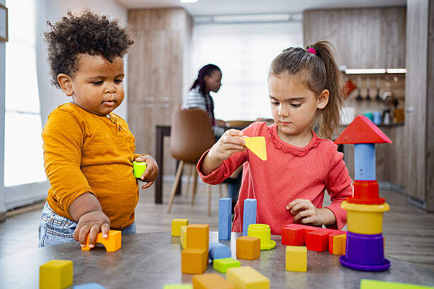 istock Two multiracial children playing building blocks at home 2220079165