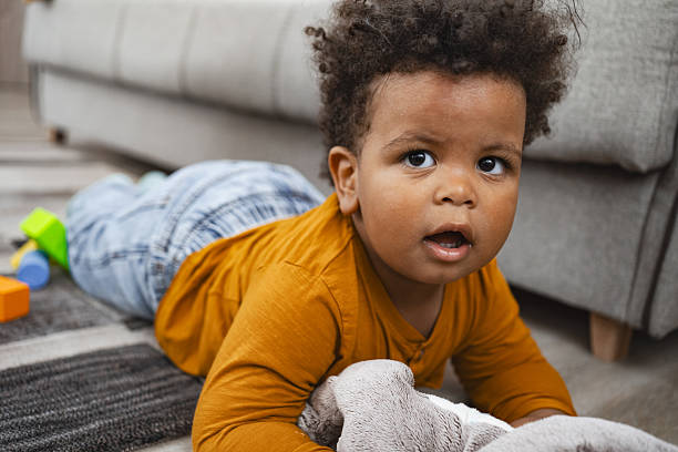 istock Curious Baby Lying on the Floor Playing with Soft Toy 2220079197