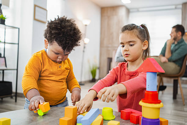 istock Two adorable children playing building blocks at home 2220079259
