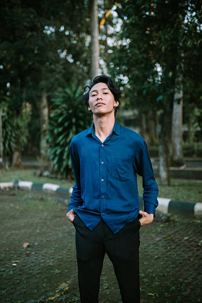 istock Confident young man poses outdoors in nature setting with casual attire 2220079262