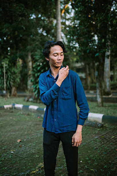 istock Thoughtful young man in blue shirt outdoors looking introspective 2220080540