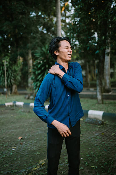 istock Young man feeling shoulder pain in a park with a grimace expression 2220080767