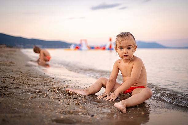 istock Little girl playing on the beach at sunset 2220086710