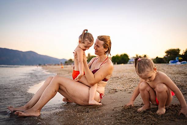 istock Mother and daughters enjoying a summer evening on the beach 2220086762