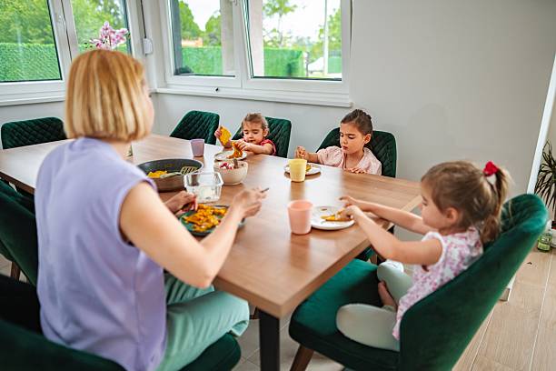 istock Mother having lunch with her three daughters at home 2220087932