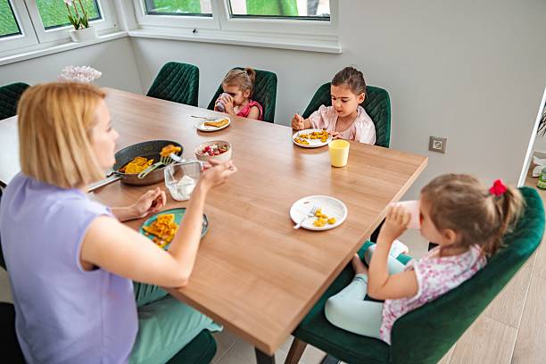 istock Mother having breakfast with her three daughters at home 2220087975