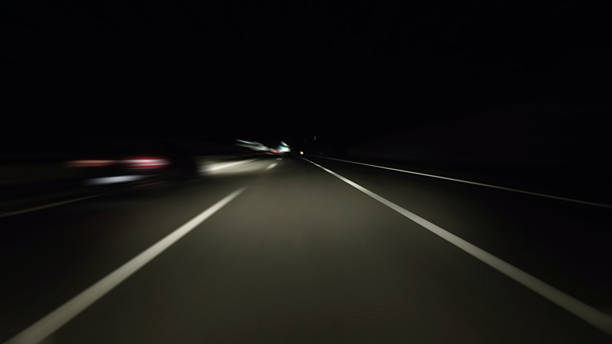 istock Driving on modern highway with bright lights on road at night 2220089437