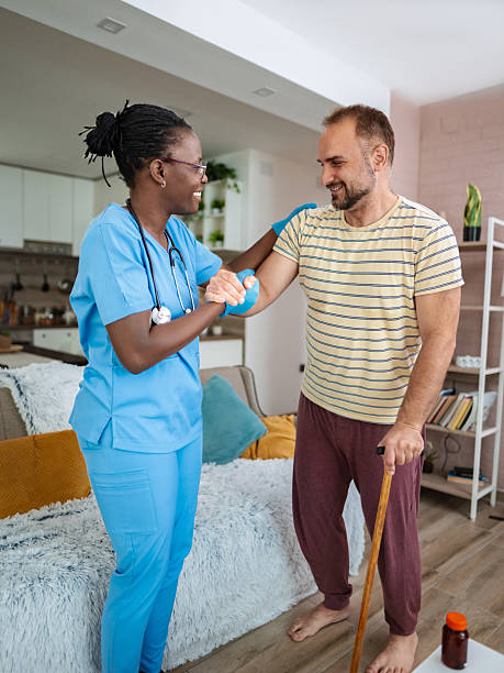 istock Nurse helping patient with walking stick during home visit 2220089706