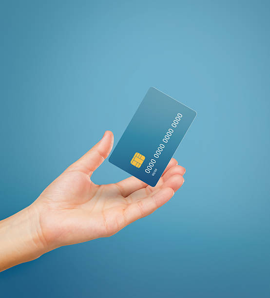 istock Hand hold credit card isolated on blue background. 2220090362