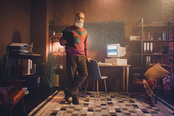 istock Mature male working on a retro computer in a cozy home office setting surrounded by warm decor and vintage equipment 2220091271