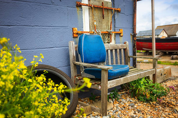 istock Lone bench with blue cushion on the pebble beach 2220092688