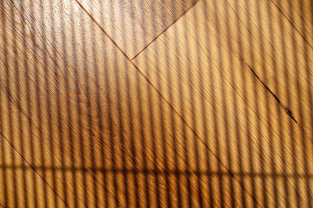 istock Beautiful patterns of light and shadow created by blinds on a wooden surface indoors in the afternoon sun 2220093963