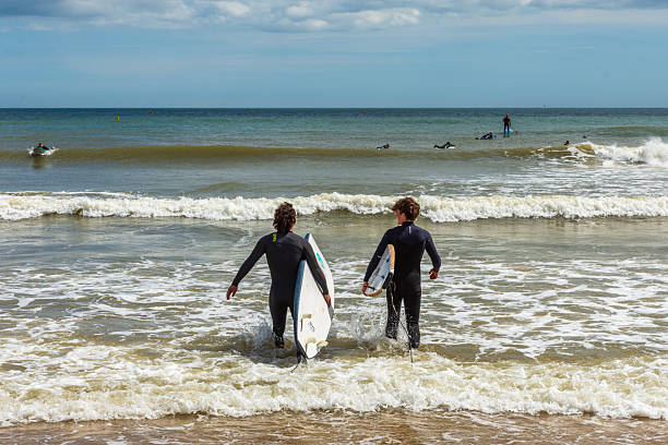 Portimão, Portugal - Dec 07, 2025:  Surfers on Praia da Rocha beach
