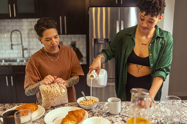 istock A lesbian woman pours milk into a bowl while making cereal for breakfast with her girlfriend 2220094838