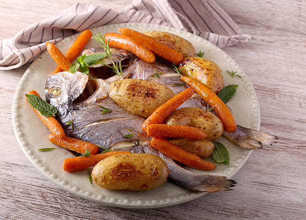 istock sea bream fish with carrot and potato 2220095215