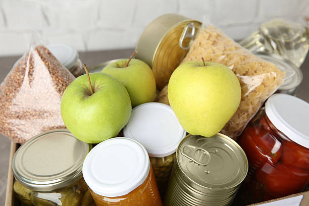 istock Different products in box on table, closeup. Food donation 2220096541