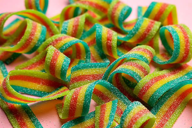 istock Tasty rainbow sour belts on pink background, closeup 2220096799