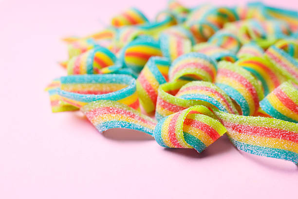 istock Tasty rainbow sour belts on pink background, closeup 2220096823