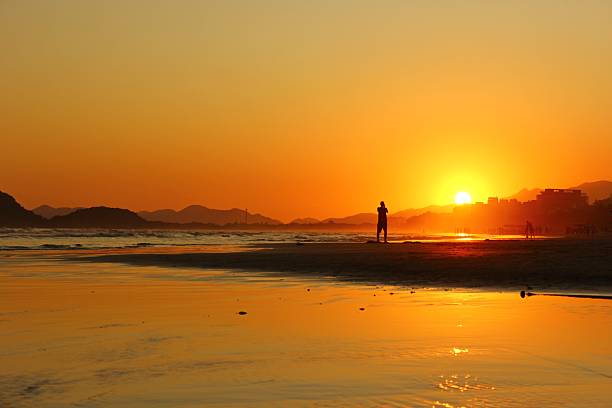 istock Reddish and golden light reflections over sky and beach wet sand. 2220097462