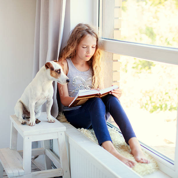 istock Girl reading book at home 2220100926