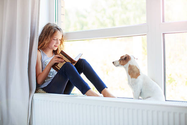 istock Girl reading book at home 2220100929