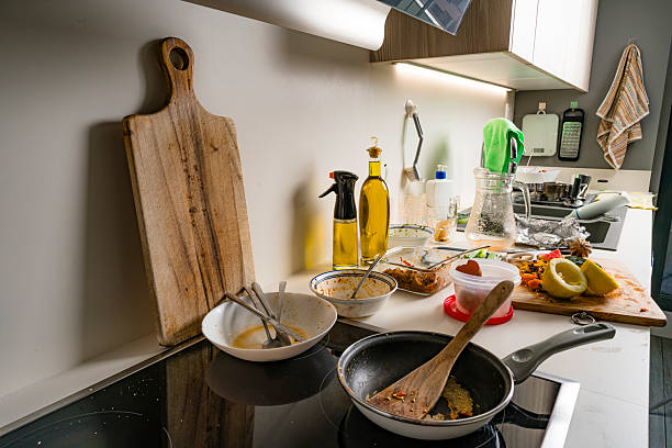 istock Messy kitchen counter, dirty plates and leftovers, cutting board, kitchen and fruits peels, unhygienic and stained crockery. Time to wash and clean up 2220105732
