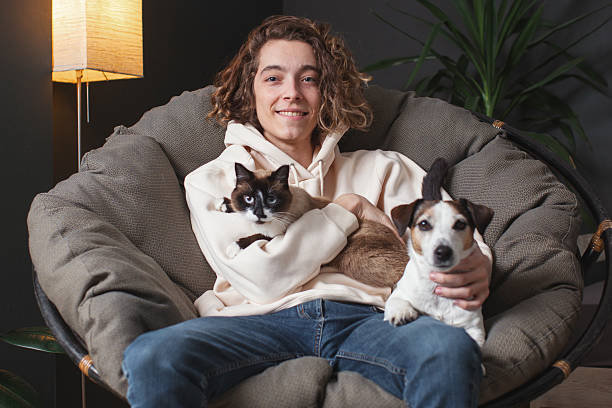 istock Man sitting on sofa with dog at home 2220106594