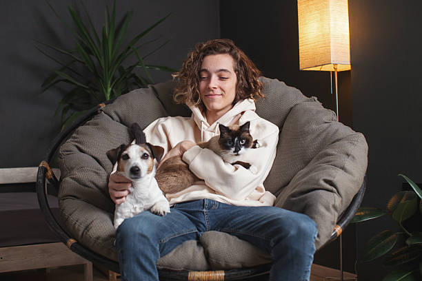 istock Man sitting on sofa with dog at home 2220106785