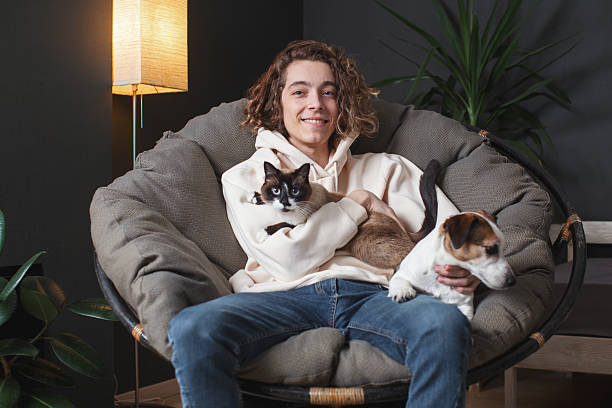 istock Man sitting on sofa with dog at home 2220106786