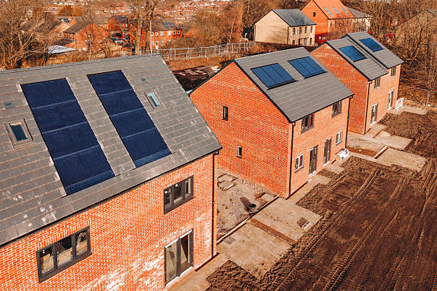 istock Aerial view from drone at new residential development featuring homes with solar panels integrated into the roofs for energy efficiency 2220107698