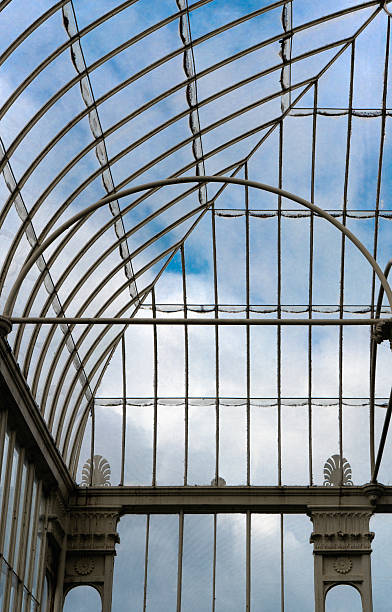 istock Arched Glasshouse Ceiling Against Blue Sky 2220107937