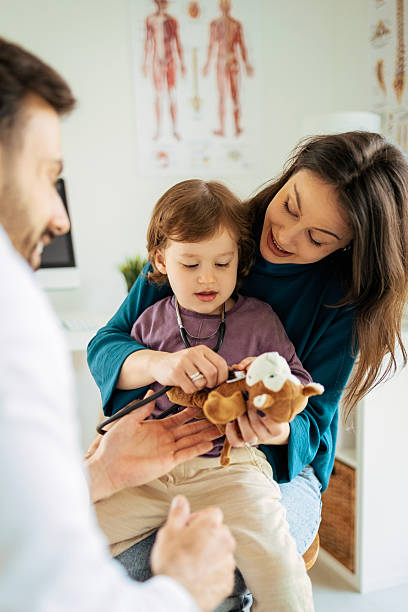 istock Doctor Making Check-Up Fun with Puppet and Stethoscope 2220110890