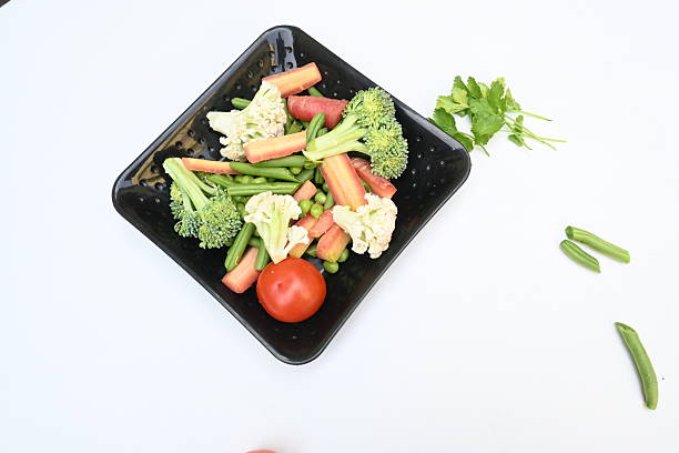 Sauteed vegetables of carrot, brocoli, and cauliflower serving on a ceramic plate. Healthy food concept