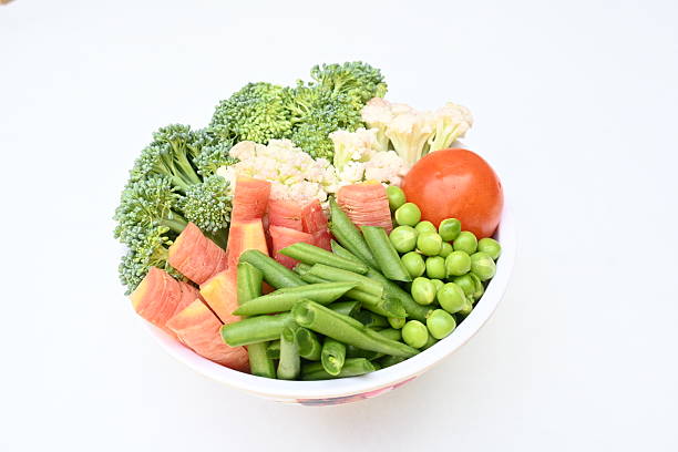 Close-up view of mixed vegetable stir fry served in a stainless steel chafing dish at a buffet setup.