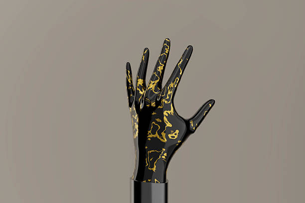 istock A hand with gold and black paint on it 2220111538