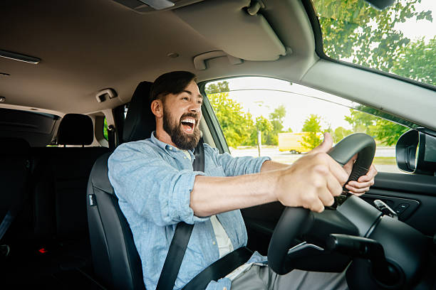 istock A handsome smiling man driving a car. 2220113587