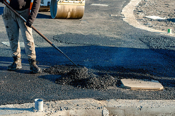 istock Construction workers in high-visibility gear are applyin gfresh hot asphalt to roadway surface 2220113969