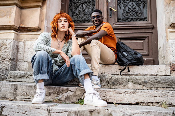 istock Two Friends Relaxing on Stone Steps During a Sunny Day 2220115735