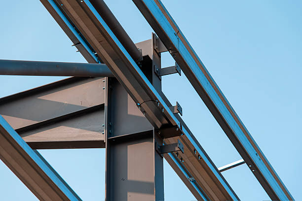 istock Steel framework supports construction of modern building in clear blue sky 2220116023
