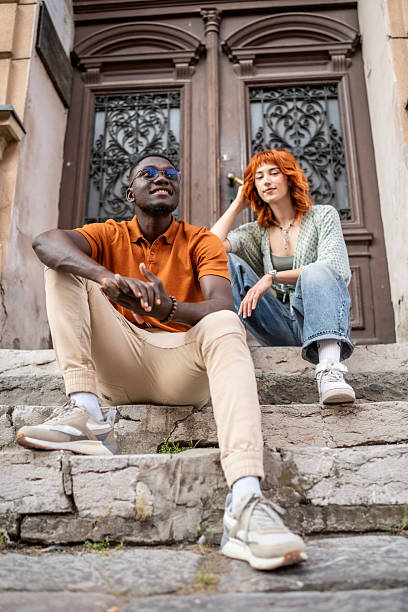 istock Two Friends Relaxing on Steps in an Urban Street Setting 2220116647