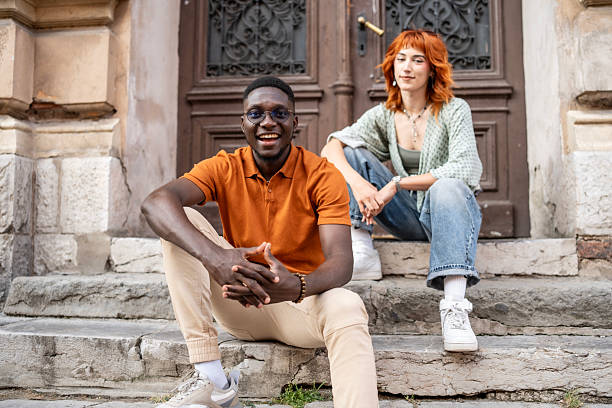 istock Two Friends Sitting on Stone Steps Outside a Historic Building 2220116654