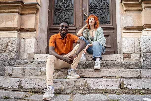 istock Stylish Young Friends Sitting Outside Historical Building Steps 2220116657